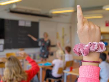 Billede af elev, der rækker hånden op i klassen